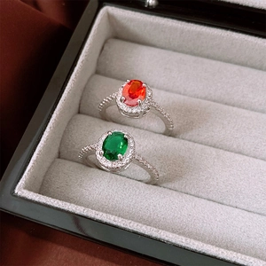 Detailed macro view of oval zircon rings in red and green set in silver velvet box
