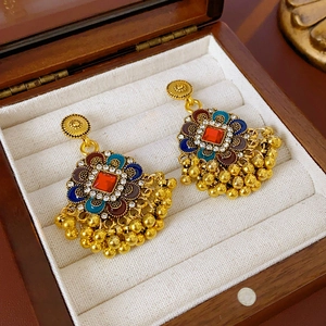 Détail de boucles d'oreilles vintage avec cristal rouge et émail coloré incrusté