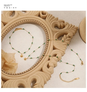 Detail of vintage gold necklace and bracelet with green beads and shell pendant