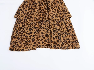 Detailed macro view of the ruffled hem on a leopard print chiffon wrap dress