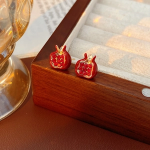 Dettaglio di orecchini a melograno vintage con pietre rosse e placcatura in oro