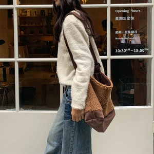 Détail d'un sac cabas en polaire marron avec coutures en toile et bandoulière chic