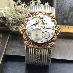 Macro detail of vintage steampunk bangle watch with exposed mechanical gear movement