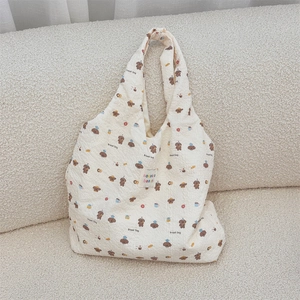 Detail of cream seersucker tote bag with brown poodle print and branded fabric label