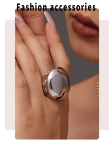 Dettaglio macro di anello in acciaio argento con ampia superficie ovale a specchio e fregi