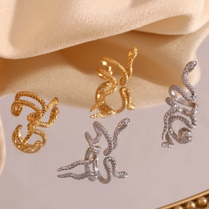 Detailed macro view of 18K gold and silver snake skin textured rings on satin