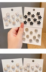 Macro detail of various pearl and rhinestone brooch pins on decorative display cards