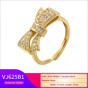 Detail of gold bow ring with pavé cubic zirconia inlay on polished brass surface