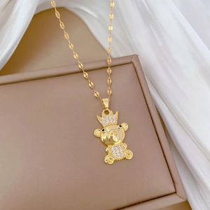 Luxurious gold bear necklace with crown and crystals on a soft white background