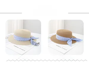 Detail of straw boater hats with blue plaid bow ribbon and small metal emblem tags