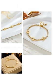 Detail of gold tennis bracelet featuring Roman numeral charms and sparkling crystals