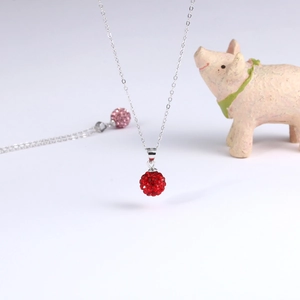 Makroaufnahme einer S925 Sterling Silber Kugelkette mit funkelnden roten Kristallen