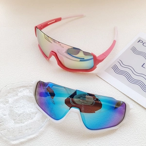 Close-up of pink and white kids cycling sunglasses with mirrored wrap lenses on stone