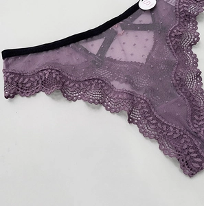 Detail shot of purple lace and polka dot mesh fabric on low-rise thong with size S tag