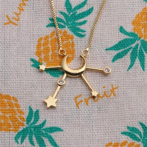 Gold star and crescent moon pendant necklace with zircon crystals on box chain