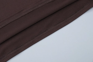 Detailed close-up showing the precise double-needle stitching on the brown knit fabric