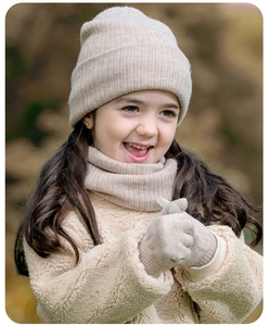 Detalle de la textura de punto del conjunto de invierno beige con gorro, bufanda y guantes