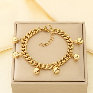 Detail view of 18K gold plated stainless steel bell bracelet on a silk background
