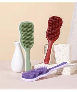 Three ergonomic detangling hairbrushes in green, red, and purple with soft bristles