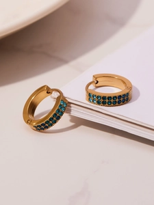 Detail view of gold-plated hinged hoop earrings with double-row blue gradient rhinestones