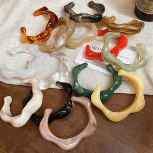 Close-up of colorful irregular wavy acrylic resin bangles in amber and tortoiseshell patterns