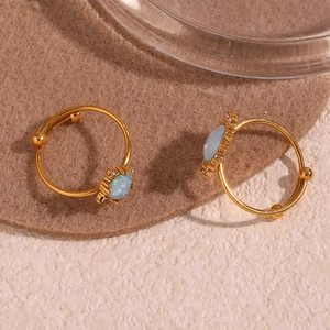 Macro detail of 18K gold plated adjustable rings featuring oval opal and tiny crystals