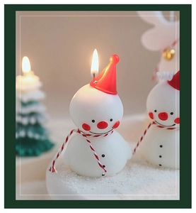 Détail d'une bougie bonhomme de neige avec chapeau rouge pour déco de Noël cocoon