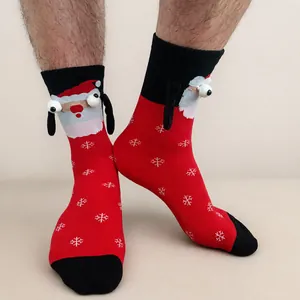 Detail of red Christmas socks with 3D Santa Claus figure and magnetic hands on wood floor