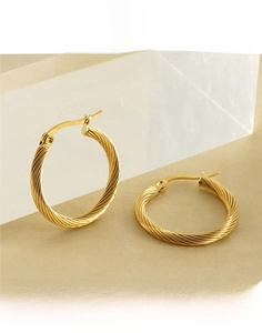 Close-up of gold-plated titanium steel hoop earrings with a twisted rope design details