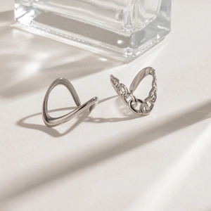 Minimalist silver ear cuff set featuring sleek organic shapes and chain designs in a chic setup