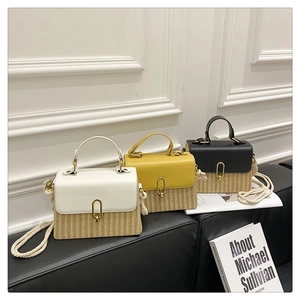 Detail of straw woven crossbody bags with leather tops and golden oval metal buckles