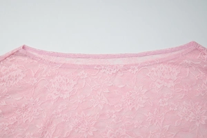 Detalle de top de encaje rosa que muestra intrincados patrones y costuras finas