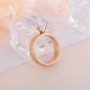 Detailed macro view of square cut white gemstone on gold ring with hammered texture band