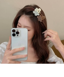 Detail of floral hair clips in white and brown worn as elegant hair accessories