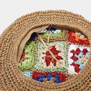 Detailed view of the woven straw hat interior with colorful crochet flower pattern