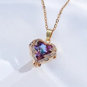 Macro shot of 18K gold plated heart pendant with purple iridescent zircon and white crystals