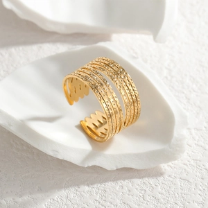 Minimalist gold C-shaped wide multi-layer ring with textured stripes on white display