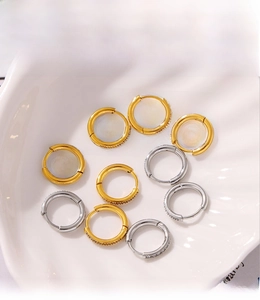 Macro detail of PVD plated gold and silver hoop earrings with pave cubic zirconia