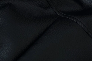 Close-up of premium black lychee texture leather jacket with detailed stitching