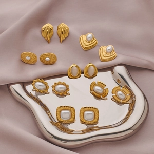 Retro gold plated earring set with pearls and gemstone studs on silk background