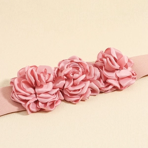 Pink elastic waist belt featuring three large decorative fabric roses on a beige background
