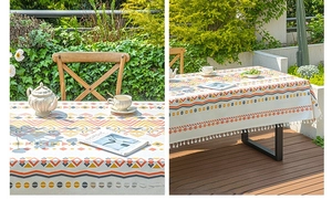 Detail of bohemian rectangle tablecloth with orange geometric patterns and white tassels