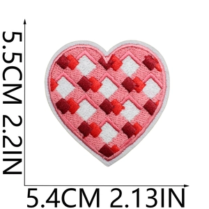 Detailed view of a heart-shaped embroidered patch with red and pink lattice patterns