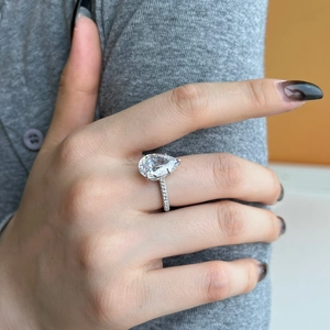 Macro shot of s925 sterling silver ring with pear-cut pink zircon and pavé setting