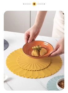 Detail of sunflower shaped silicone heat resistant table mat in various colors and sizes