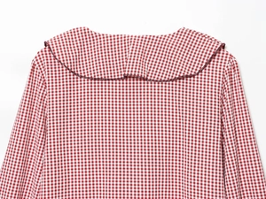 Detail view of red and white gingham shirt collar and cotton fabric texture on white background
