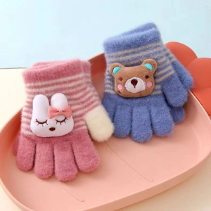 Gros plan de gants tricotés pour enfants avec des motifs mignons de lapin et d'ours