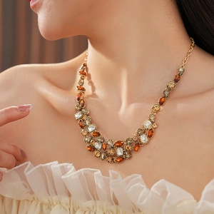 Detailed close-up of vintage gold necklace featuring amber and clear water-drop crystals