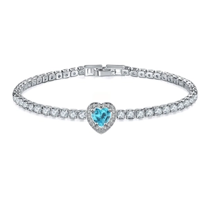 Detailed close-up of a silver tennis bracelet featuring a light blue heart-shaped gemstone