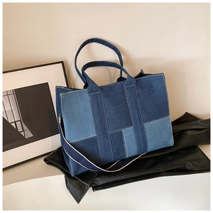 Detail showing geometric denim patchwork tote with contrast stitching and wide strap